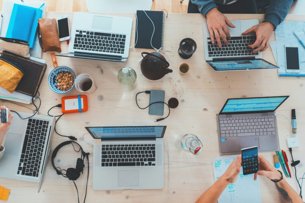 Tworzenie contentu dla firmy. Biurko z laptopami – atmosfera kreatywnej pracy.