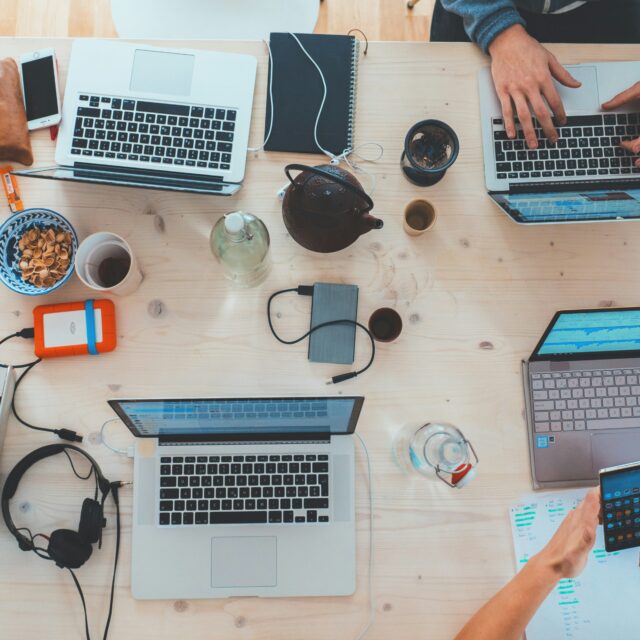 Tworzenie contentu dla firmy. Biurko z laptopami – atmosfera kreatywnej pracy.